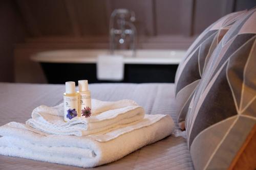 a pile of towels and candles on a bed at The Westleton Crown in Westleton