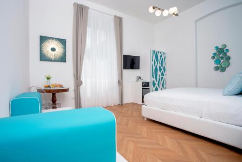 a white bedroom with a bed and a table at Relais al Castello in Castellammare di Stabia