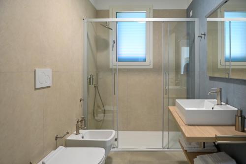 a bathroom with a shower and a toilet and a sink at Terra Home Resort in Spongano