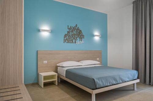 Terra Home Resort في Spongano: غرفة نوم بسرير مع جدار ازرق