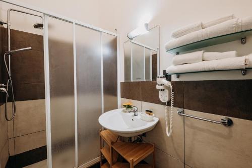 La salle de bains est pourvue d'un lavabo et d'une douche. dans l'établissement Kyanos Residence, à Syracuse