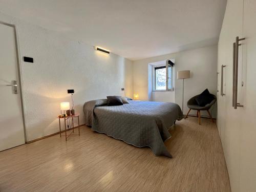 a bedroom with a bed and a chair and a window at Apartment Eleni in Rovinj