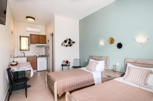 1 dormitorio con 2 camas y cocina en Ipsos Pool Apartments, Elena & Maria by Konnect, en Ýpsos