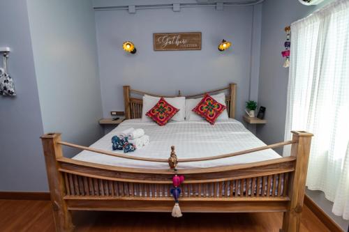 1 dormitorio con 1 cama grande con marco de madera en Chiang mai Walking Street Home ( เชียงใหม่วอล์คกิ้งสตรีทโฮม ), en Chiang Mai