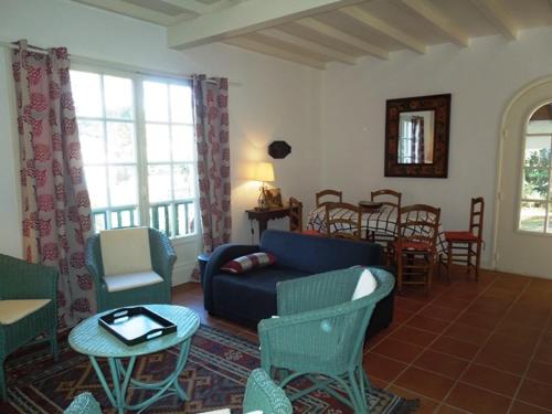 un salon avec un canapé, des chaises et une table dans l'établissement Enea - Hossegor agréable villa proche du lac et de la plage, à Soorts-Hossegor