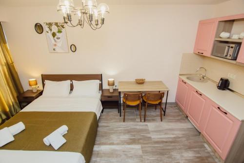 a hotel room with two beds and a sink and a table at Real Beach Tower in Batumi