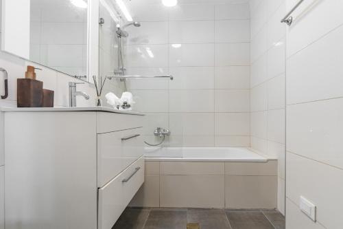 ein weißes Bad mit einem Waschbecken und einer Dusche in der Unterkunft Luxury and Large 2 Bedroom - Rav Kuk Residence in Jerusalem