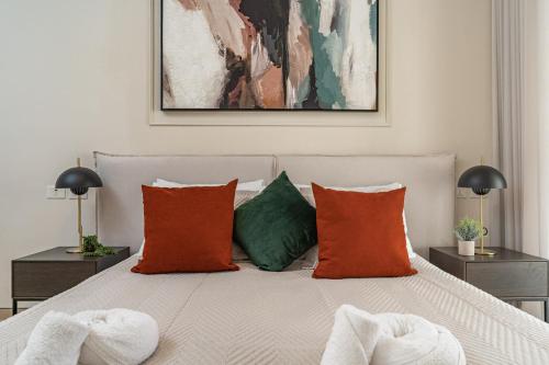 ein Schlafzimmer mit einem Bett mit orangefarbenen und grünen Kissen in der Unterkunft Luxury and Large 2 Bedroom - Rav Kuk Residence in Jerusalem