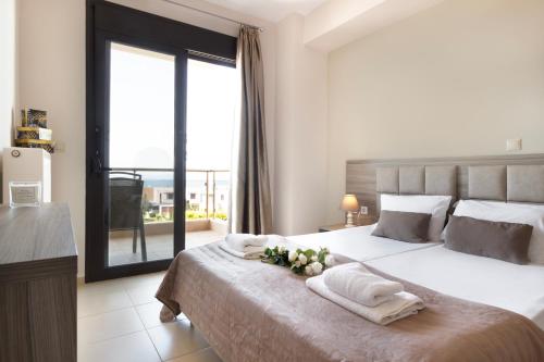 a bedroom with a large bed with a large window at Villa Orelia in Hanioti