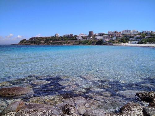 a view of a beach with rocks in the water at Calasetta Comfy Apartment x5 - w/ Terrace in Calasetta