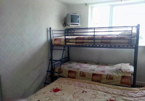 ein kleines Schlafzimmer mit 2 Etagenbetten und einem Fenster in der Unterkunft Lynwood Hotel & Spa in Blackpool