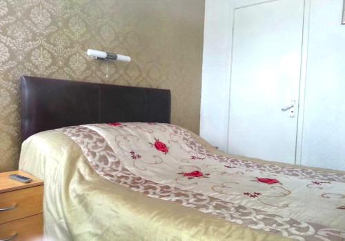 Una cama con una cabecera marrón con rosas. en Lynwood Hotel & Spa en Blackpool