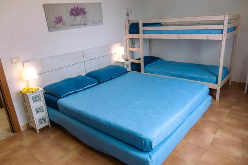 a bedroom with a blue bed and bunk beds at Calasetta Comfy Apartment x5 - w/ Terrace in Calasetta
