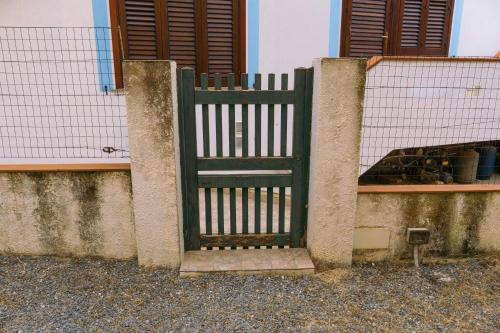 a green gate in front of a building at Calasetta Comfy Apartment x5 - w/ Terrace in Calasetta