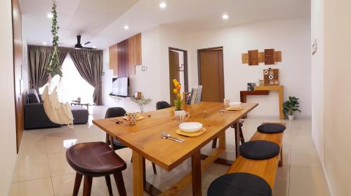 eine Küche und ein Esszimmer mit einem Holztisch und Stühlen in der Unterkunft Ipoh Homestay - Manhattan Condominium with Water Park & Leisure Facilities in Ipoh