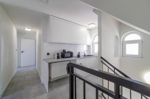 a white kitchen with a counter and a staircase at Wczasowa 8 Apartments in Sarbinowo