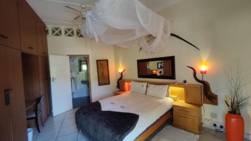 a bedroom with a large bed with a pillow on it at Maison Ambre Guesthouse in Windhoek