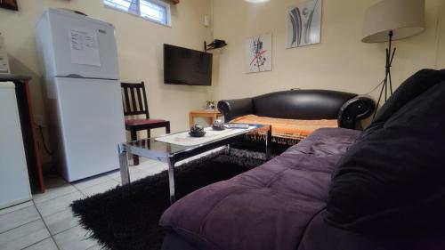 a living room with a couch and a table at Maison Ambre Guesthouse in Windhoek
