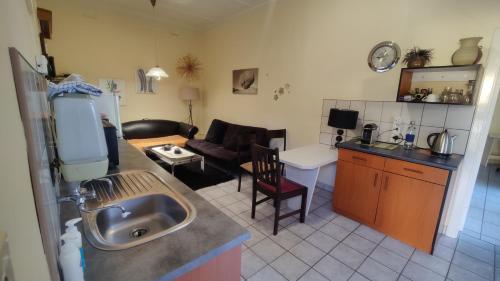 a kitchen and a living room with a sink at Maison Ambre Guesthouse in Windhoek