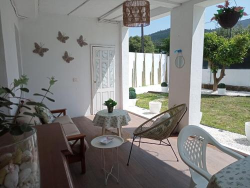 a living room with chairs and a table and a patio at Apartamento entero con jardín en Casa Amelia in Padrón
