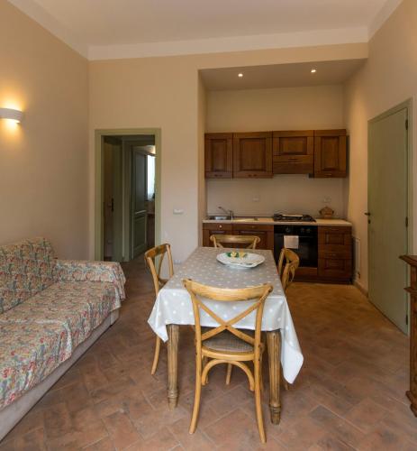 a living room with a table and chairs and a couch at Tenuta Agricola dell'Uccellina in Talamone