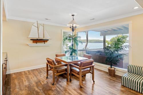 a dining room with a table and a sailboat on the wall at Grammy and Papas Lakeside Dugout in Osage Beach