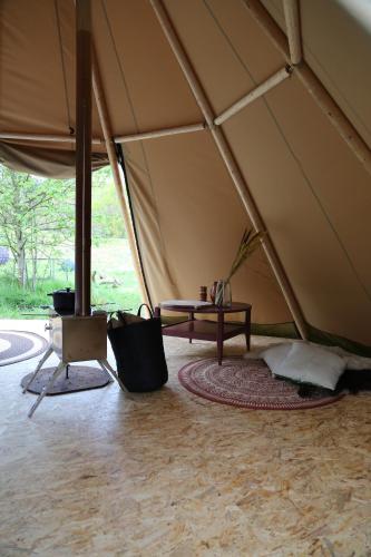 ein Zelt mit einem Tisch in der Mitte eines Zimmers in der Unterkunft Tipi Texel in 't Horntje