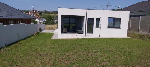 a small white house with a yard at Vila Andrea in Oradea