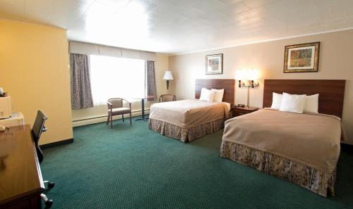 Travelers Inn في برونزويك: غرفة فندقية بسريرين ونافذة