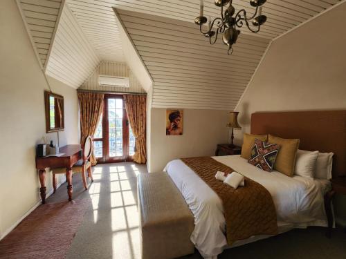 sypialnia z łóżkiem i biurkiem w pokoju w obiekcie Dark Chocolate Guest House w mieście Durbanville