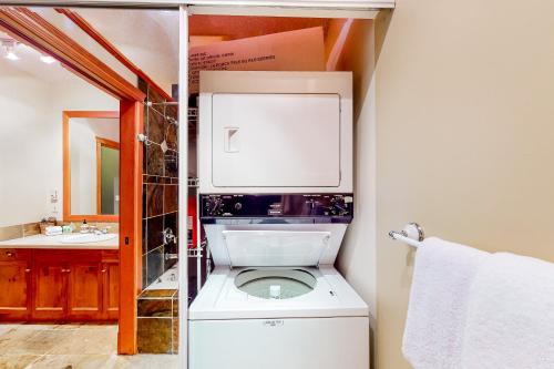 a bathroom with a toilet and a sink in it at Snow Leopard's Retreat in Big White