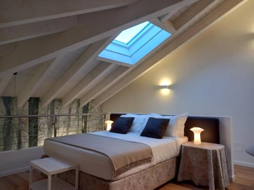 a bedroom with a large bed with a skylight at Vivila - Ca' Foulard in Cernusco sul Naviglio