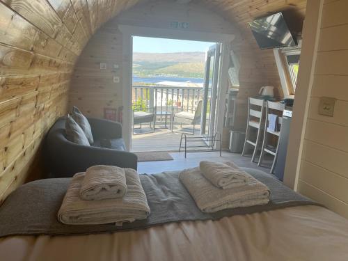 a bedroom with a bed with towels on it at Bonnie Brae Pod in Fort William