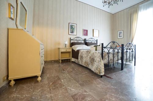 una camera con letto, cassettiera e scala di I Balconi sul Barocco a Modica
