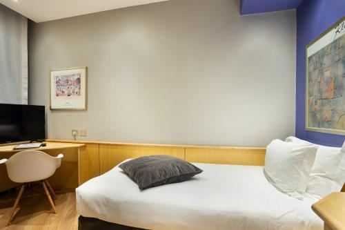 a bedroom with a bed and a desk with a television at Best Western Plus Executive Hotel and Suites in Turin