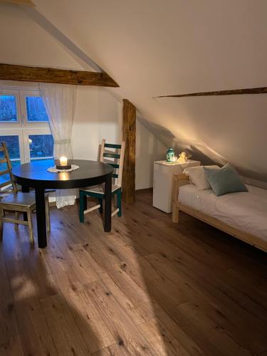 een kamer met een tafel, een bed en een raam bij Rancho „Czajone na pigwowcu” 