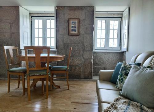 a living room with a table and chairs and a couch at Casa Recanto do Teatro in Lamego