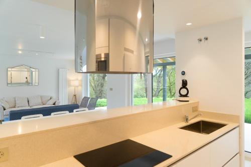 a kitchen with a sink and a living room at Villa El Rodal in Pontones