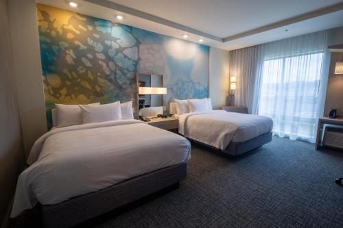 a hotel room with two beds and a large window at Courtyard by Marriott Cartersville in Cartersville