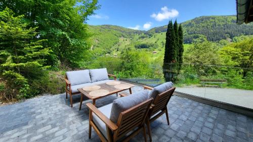 a patio with two chairs and a table with a view at Maal Waldhaus in Todtnau
