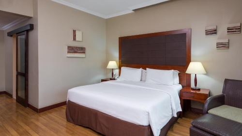 a hotel room with a large bed and a chair at Park Inn by Radisson, Lagos Victoria Island in Lagos