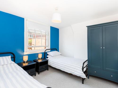 - 2 lits dans une chambre aux murs bleus dans l'établissement Pass the Keys Central Leamington Spa 2 Bed Flat with Parking, à Leamington Spa