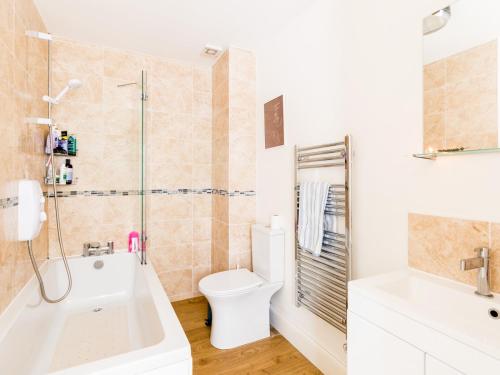 a bathroom with a tub and a toilet and a sink at Pass the Keys Central Leamington Spa 2 Bed Flat with Parking in Leamington Spa