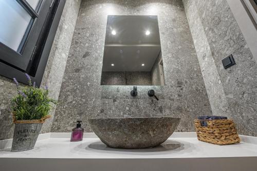 a bathroom with a stone sink and a mirror at Eleni Zirganou Studios & Apartments in Milína