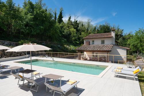 a pool with tables and chairs and a house at Villa Noemi in Querce