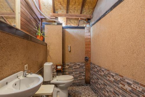 a bathroom with a toilet and a sink at Maha Nusa Menjangan in Banyuwedang