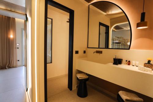 a bathroom with a sink and a mirror at Brilliance of Mykonos in Glastros