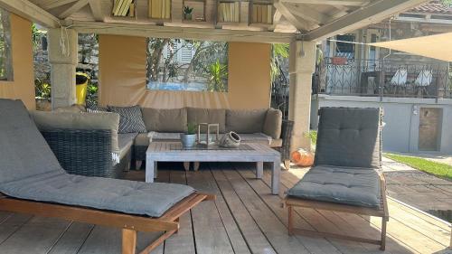 a patio with two chairs and a table on a deck at Stone house Chiara Seaview in Funtana