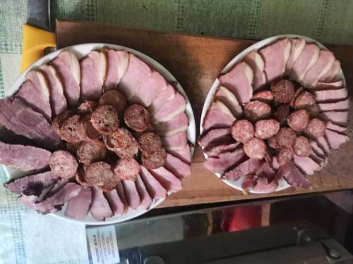 two plates of meat on a cutting board at Šumadijska panorama in Topola