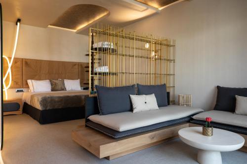 a bedroom with a bed and a couch and a table at Brilliance of Mykonos in Glastros